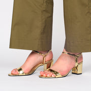 Model wearing Lavish and Squalor Liquid Gold Heeled Sandals. Size 44 womens shoes