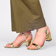 Model wearing Lavish and Squalor Liquid Gold Heeled Sandals. Size 43 womens shoes