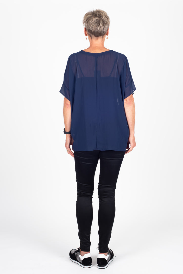 Tall model wearing Breezy Top Sapphire, back untucked