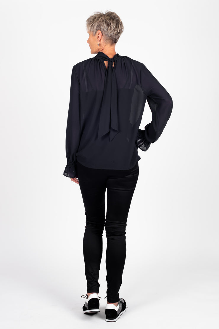 Tall model wearing Millie REVERSIBLE Top Black, back 1 with tie detail