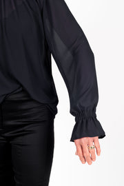 Tall model wearing Millie REVERSIBLE Top Black, sleeve detail