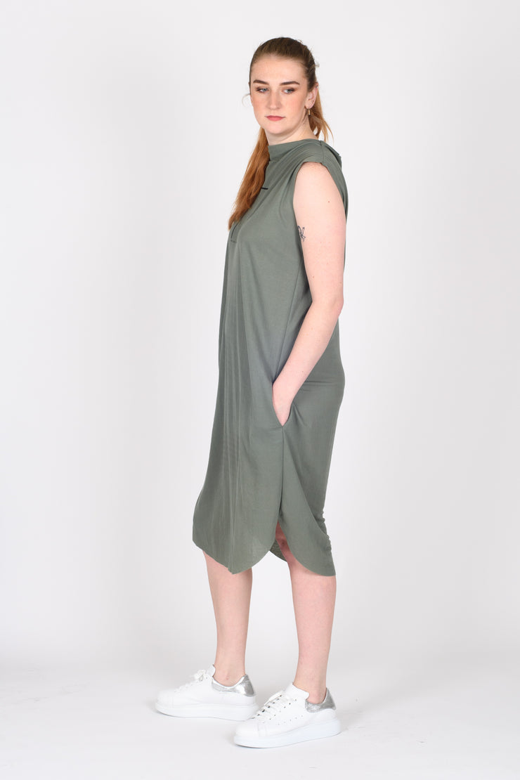 Tall model with hands in pockets of Out of Box Dress Sage for tall women
