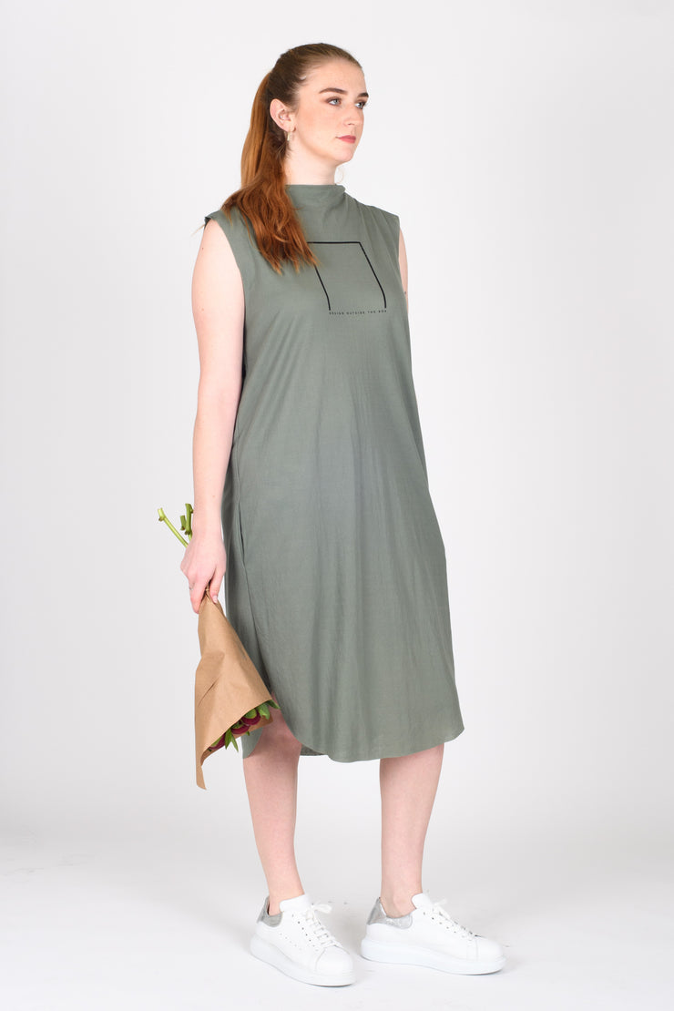 Tall model holding flowers wearing Out of Box Dress Sage for tall women