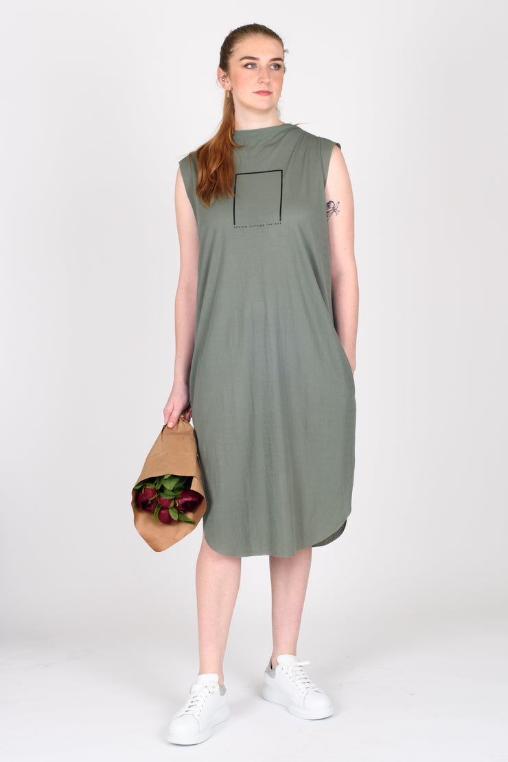 Tall woman holding flowers wearing Out of Box Dress Sage for tall women