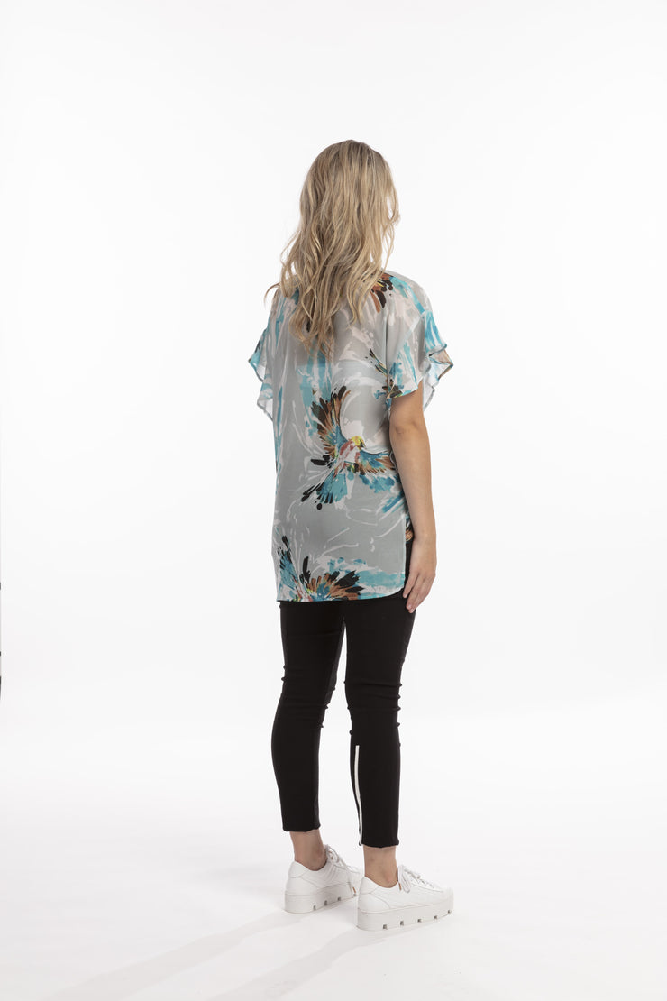 Back view of model wearing Style X Lab Fly Away Top in Turquoise Print. Made longer for tall women